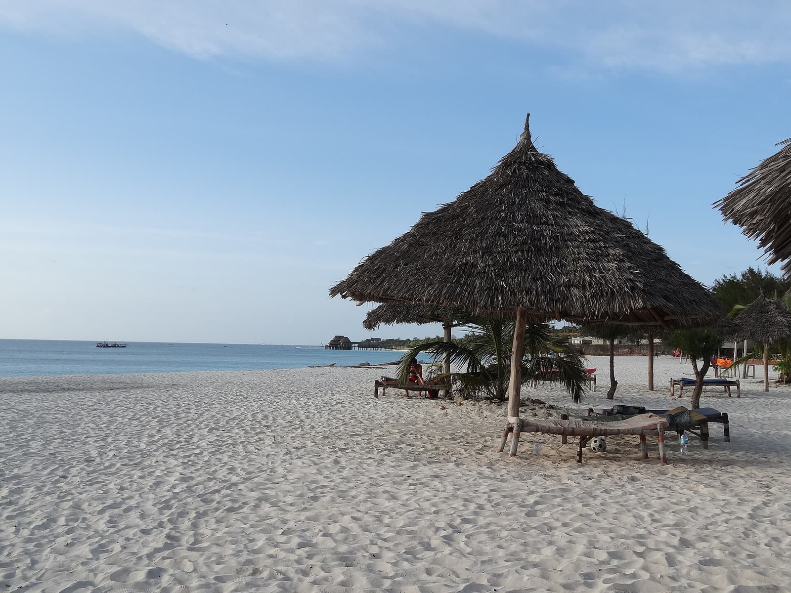 Thatched sun shelters on the wide white sand of Kendwa Beach, Zanzibar